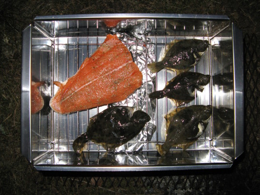 A piece of salmon and four small flounders ready to be smoked. Pala lohta ja neljä pientä kampelaa valmiina savustusta varten.