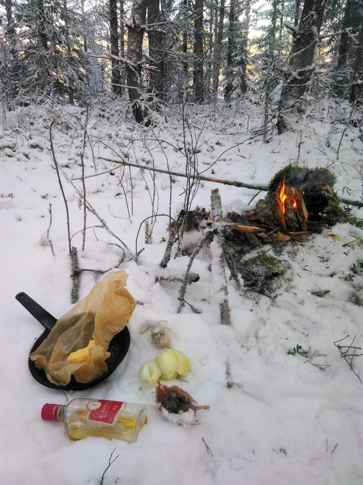 Cooking game birds at campfire in winter